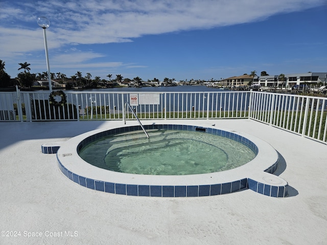 view of pool featuring a community hot tub and a water view