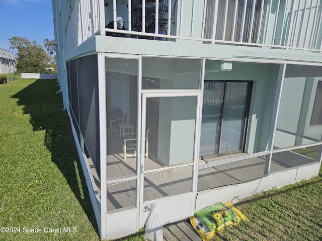 exterior space featuring a lawn and a balcony