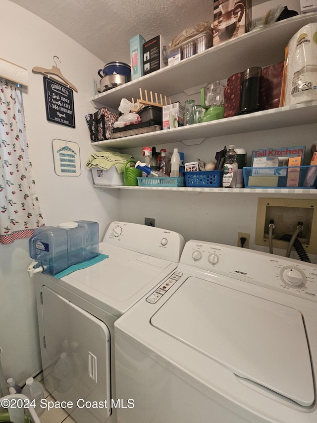 clothes washing area featuring separate washer and dryer and a textured ceiling