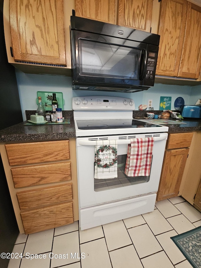 kitchen featuring white range with electric stovetop and light tile patterned flooring