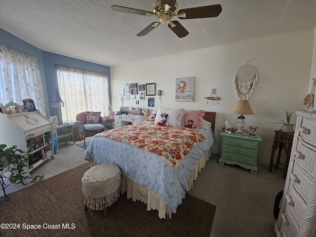 carpeted bedroom featuring ceiling fan and a textured ceiling