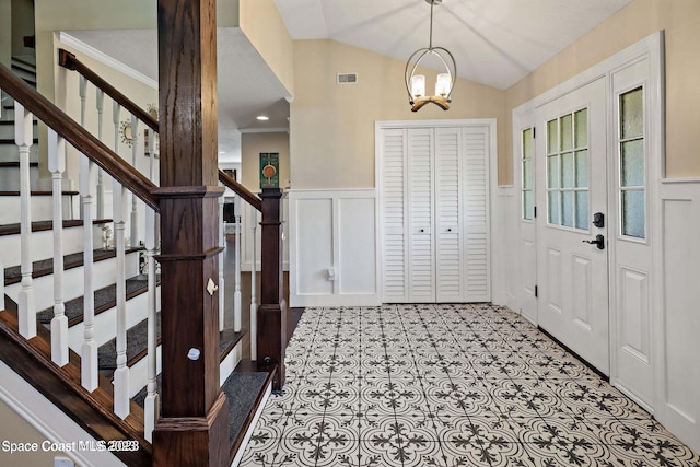 entryway featuring ornamental molding, an inviting chandelier, and lofted ceiling