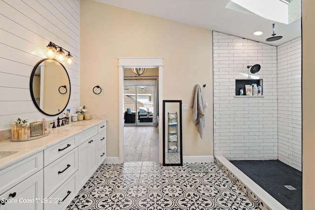 bathroom featuring a tile shower, lofted ceiling with skylight, vanity, and wood-type flooring