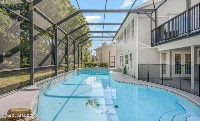 view of swimming pool with french doors, a patio area, and a lanai