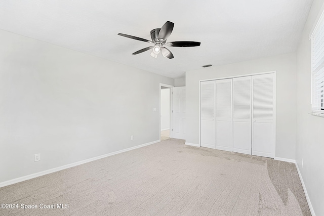 unfurnished bedroom with carpet flooring, ceiling fan, and a closet