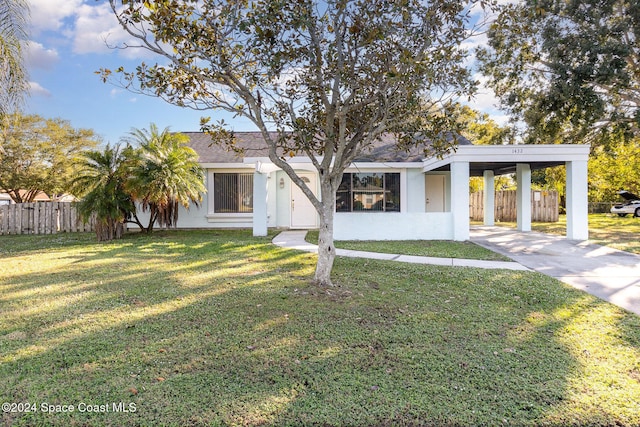 view of front of home with a front yard and a carport