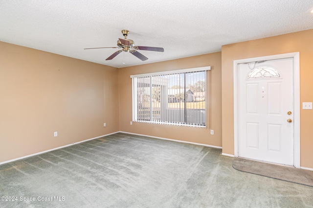 foyer with carpet, a textured ceiling, and ceiling fan