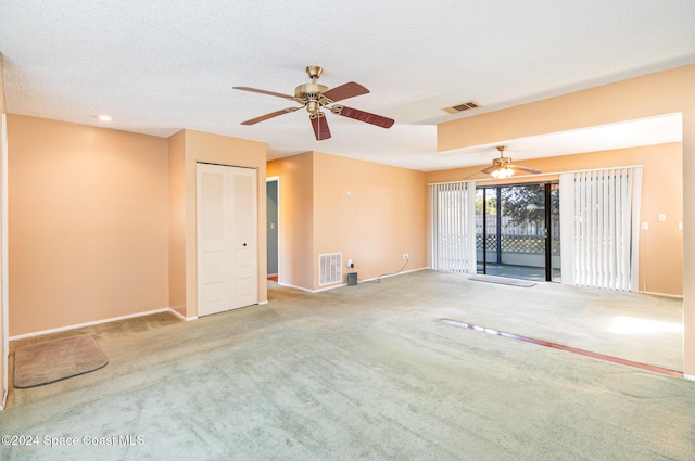 carpeted empty room with a textured ceiling and ceiling fan