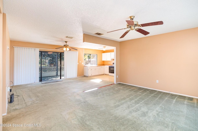 unfurnished living room featuring light carpet and a textured ceiling