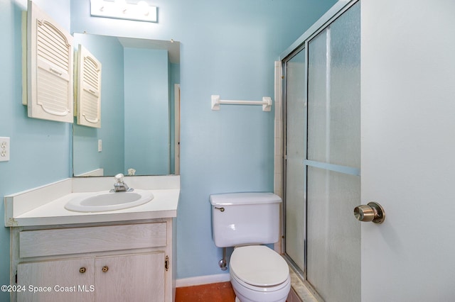 bathroom featuring vanity, toilet, and a shower with door