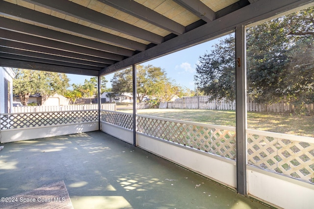 unfurnished sunroom featuring beam ceiling