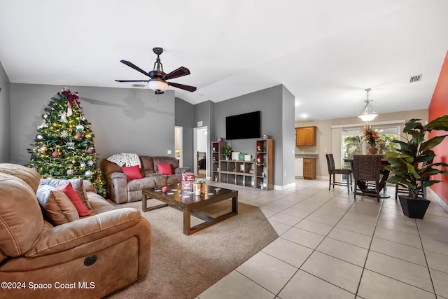 living room featuring ceiling fan, light tile patterned flooring, and vaulted ceiling