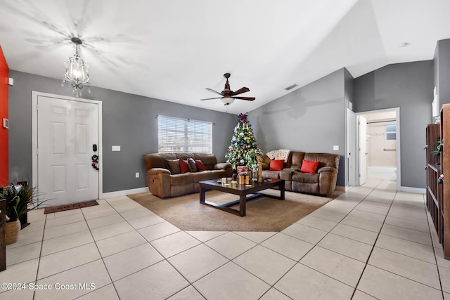 tiled living room featuring ceiling fan with notable chandelier and vaulted ceiling