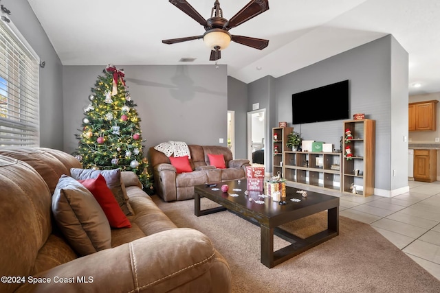 living room featuring ceiling fan, light tile patterned floors, and lofted ceiling