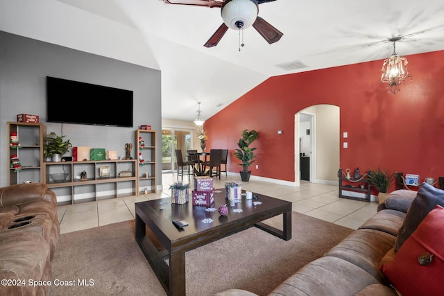 tiled living room featuring ceiling fan with notable chandelier and vaulted ceiling