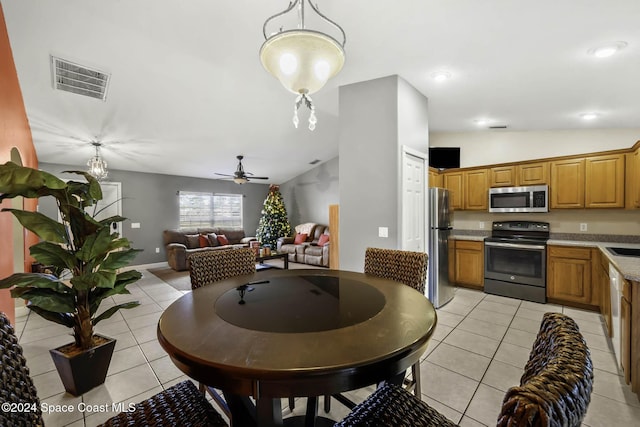 dining area featuring ceiling fan, sink, light tile patterned floors, and lofted ceiling