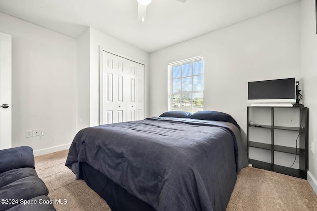 carpeted bedroom with ceiling fan and a closet