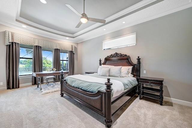 carpeted bedroom with a raised ceiling, ceiling fan, and crown molding