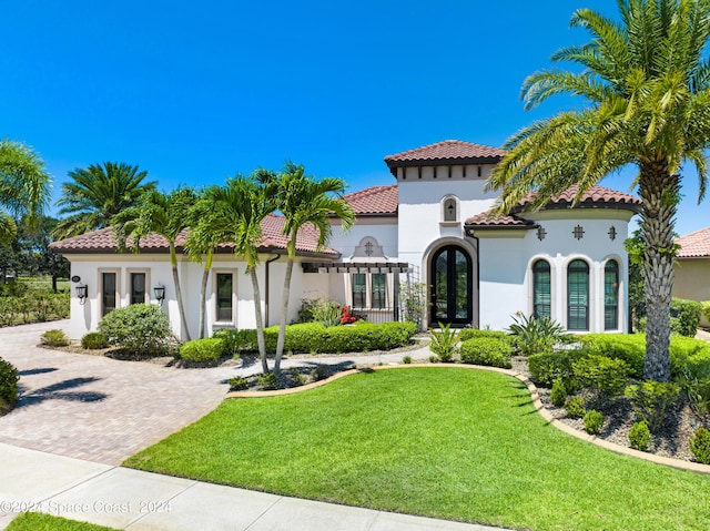 mediterranean / spanish house featuring french doors and a front yard