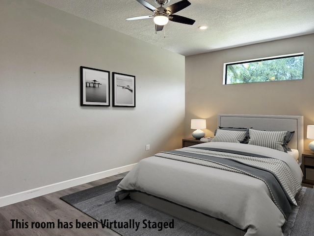 bedroom with hardwood / wood-style floors, ceiling fan, and a textured ceiling