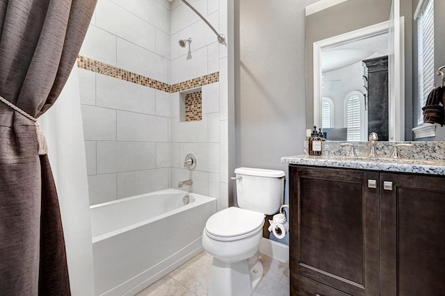 full bathroom with vanity, tiled shower / bath combo, toilet, and tile patterned flooring