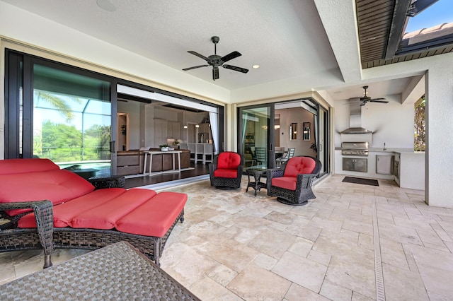 view of patio featuring a grill, ceiling fan, and an outdoor kitchen