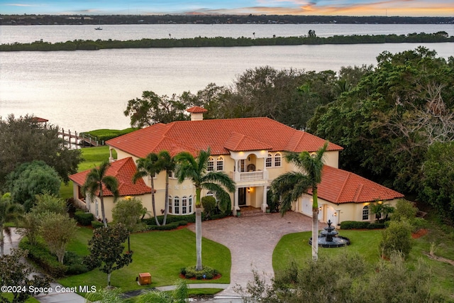 aerial view at dusk featuring a water view