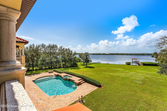 view of pool with a lawn and a water view