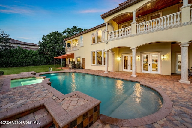 4760 Honeyridge Ln, Merritt Island, FL 32952 - pool at dusk with french doors, a patio area, and a pool with connected hot tub