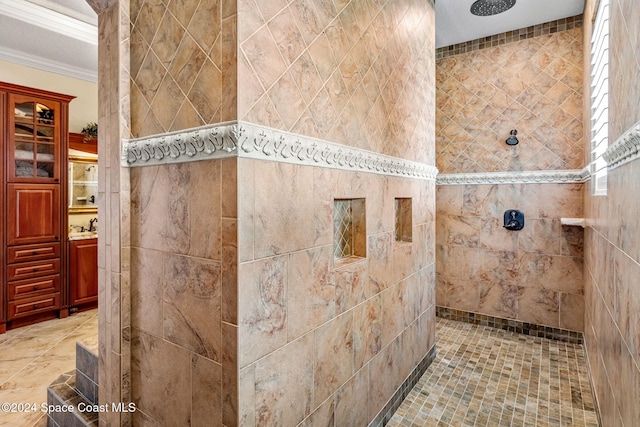 bathroom with a tile shower, vanity, tile walls, and crown molding