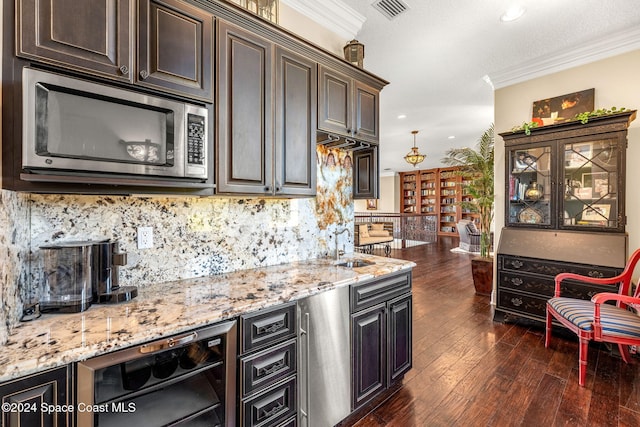 kitchen with decorative backsplash, ornamental molding, dark brown cabinetry, wine cooler, and stainless steel microwave