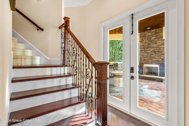 doorway featuring hardwood / wood-style floors, a fireplace, and crown molding