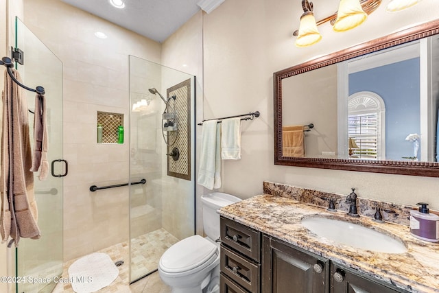 bathroom with vanity, a shower with shower door, and toilet