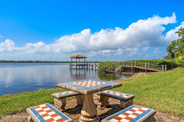 dock area with a water view and a yard