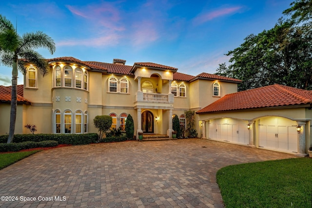 mediterranean / spanish-style home with a garage and a balcony