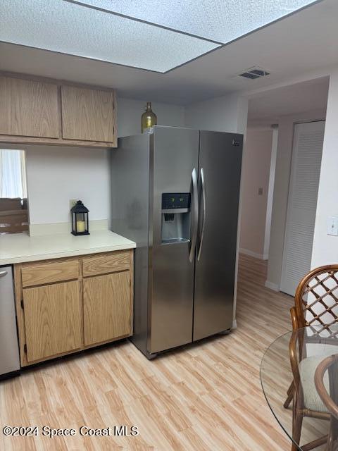 kitchen with light hardwood / wood-style flooring and appliances with stainless steel finishes