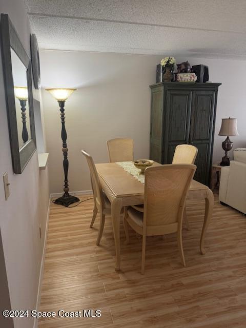 dining room featuring light hardwood / wood-style floors and a textured ceiling