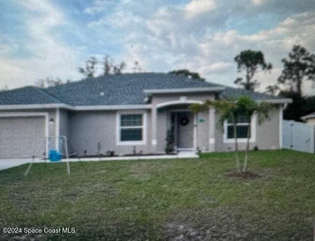 view of front of property with a front lawn and a garage