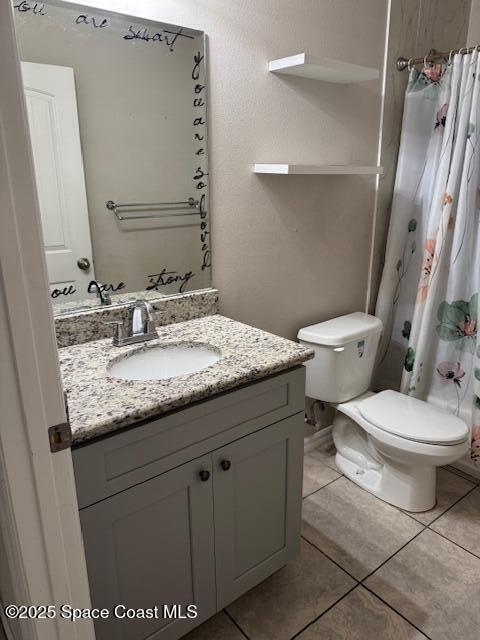 bathroom featuring vanity, toilet, tile patterned floors, and walk in shower