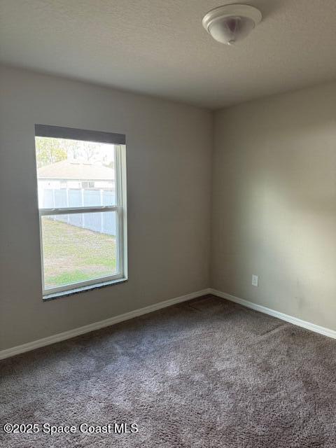 spare room featuring carpet flooring and a textured ceiling