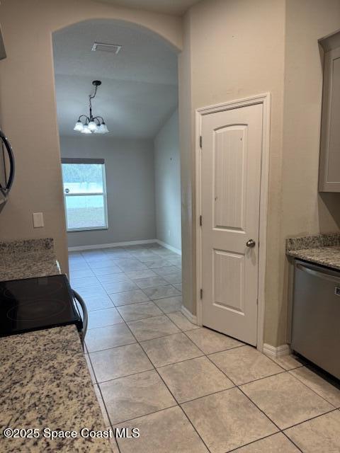 kitchen with light stone countertops, stainless steel dishwasher, light tile patterned floors, a chandelier, and pendant lighting