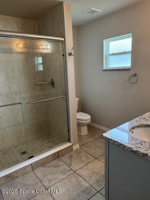 bathroom featuring vanity, an enclosed shower, toilet, and a textured ceiling