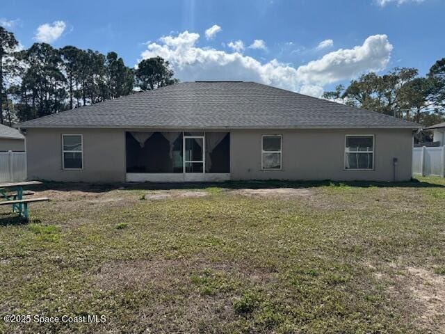 rear view of property with a yard