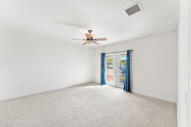 unfurnished room featuring light carpet, french doors, a textured ceiling, and ceiling fan