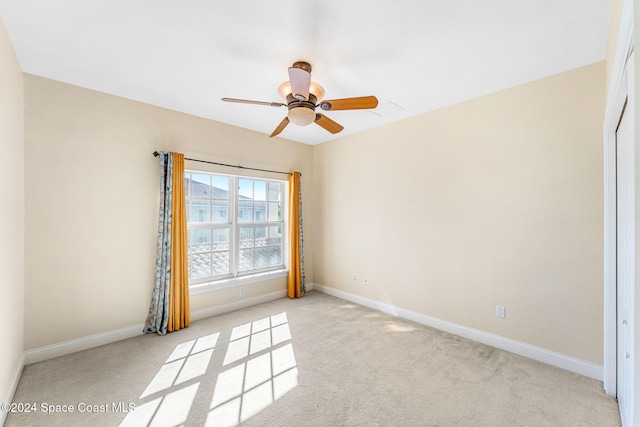 spare room featuring light colored carpet and ceiling fan