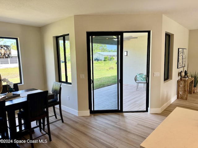 doorway to outside with light hardwood / wood-style floors and a textured ceiling