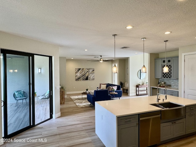 kitchen featuring stainless steel dishwasher, gray cabinets, and light hardwood / wood-style flooring