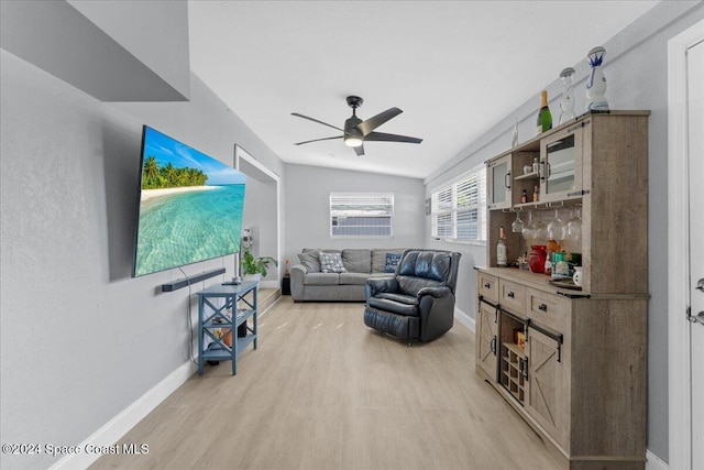 living room with ceiling fan, light hardwood / wood-style floors, and lofted ceiling