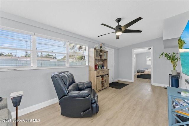 living area featuring ceiling fan, light hardwood / wood-style floors, and lofted ceiling