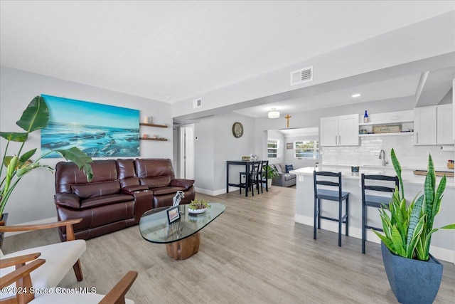 living room featuring light hardwood / wood-style flooring and sink